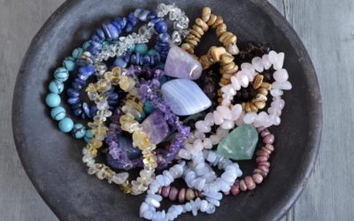 Healing properties of gemstones and crystals on a pottery bowl with wooden background