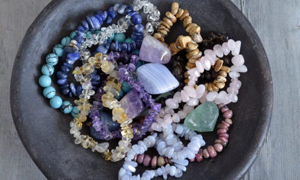 Healing properties of gemstones and crystals on empty wooden background Healing properties of gemstones and crystals on a pottery bowl with wooden background